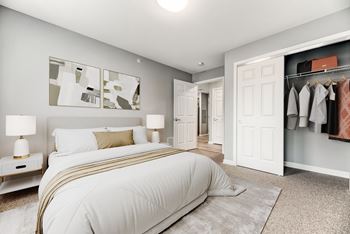 A bedroom with a large bed and a closet
